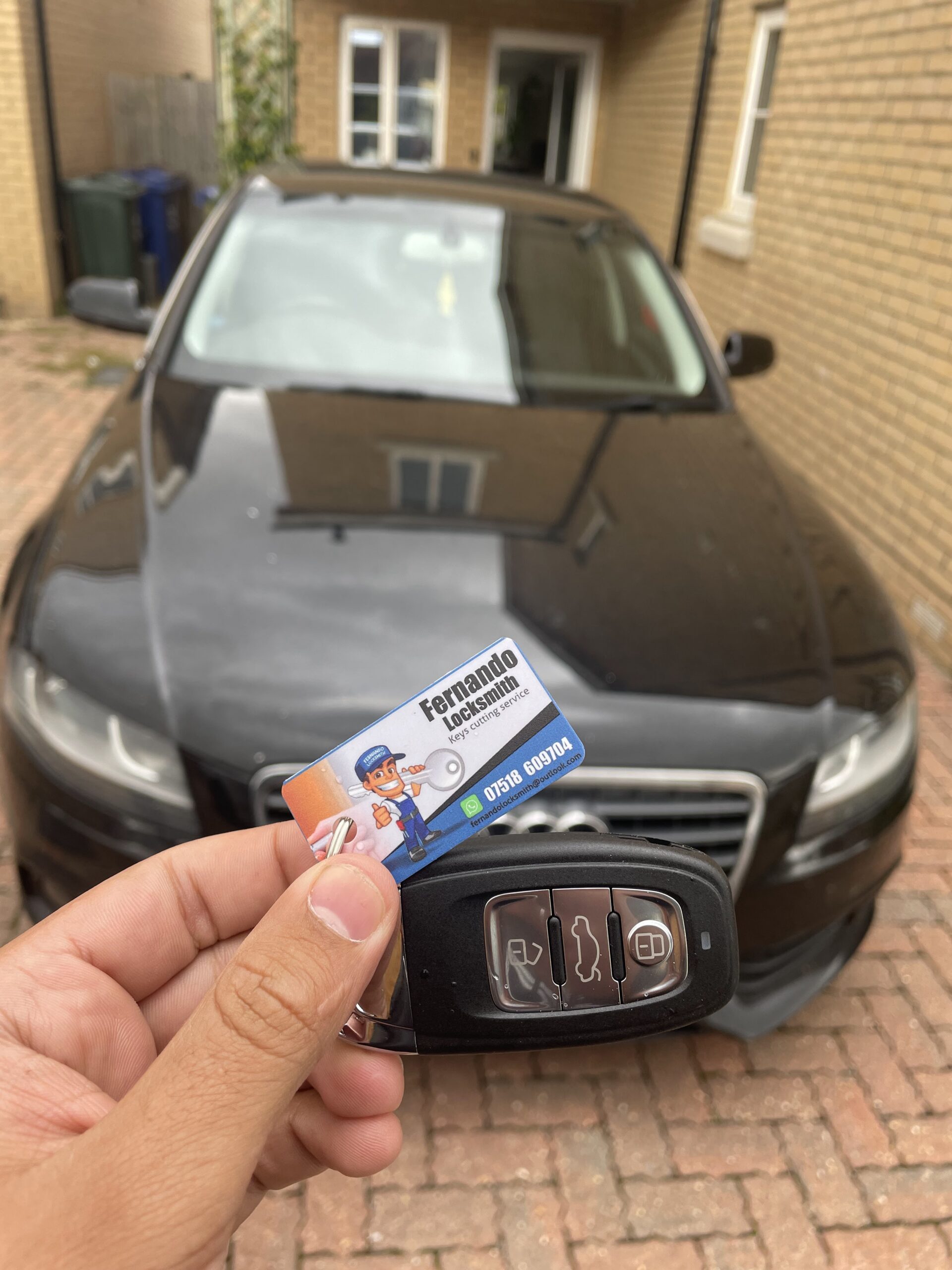 Audi remote car key displayed beside an Audi vehicle, example of automotive key services