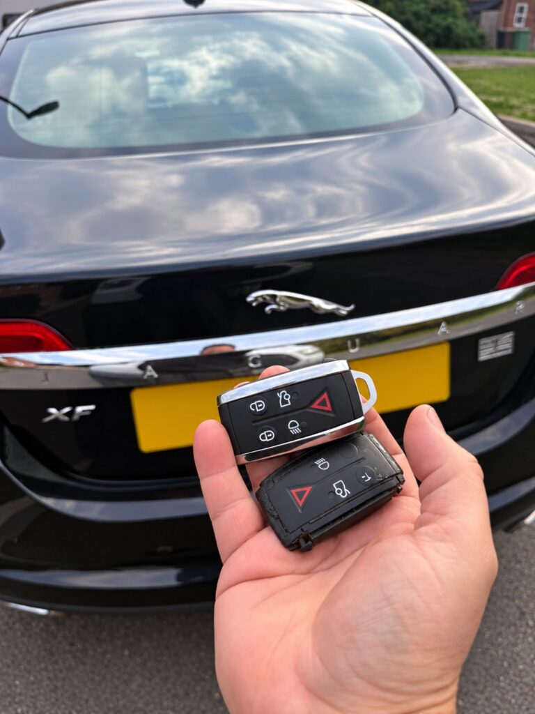 Old and new Jaguar keys held in front of the vehicle after a mobile key service in Abingdon.